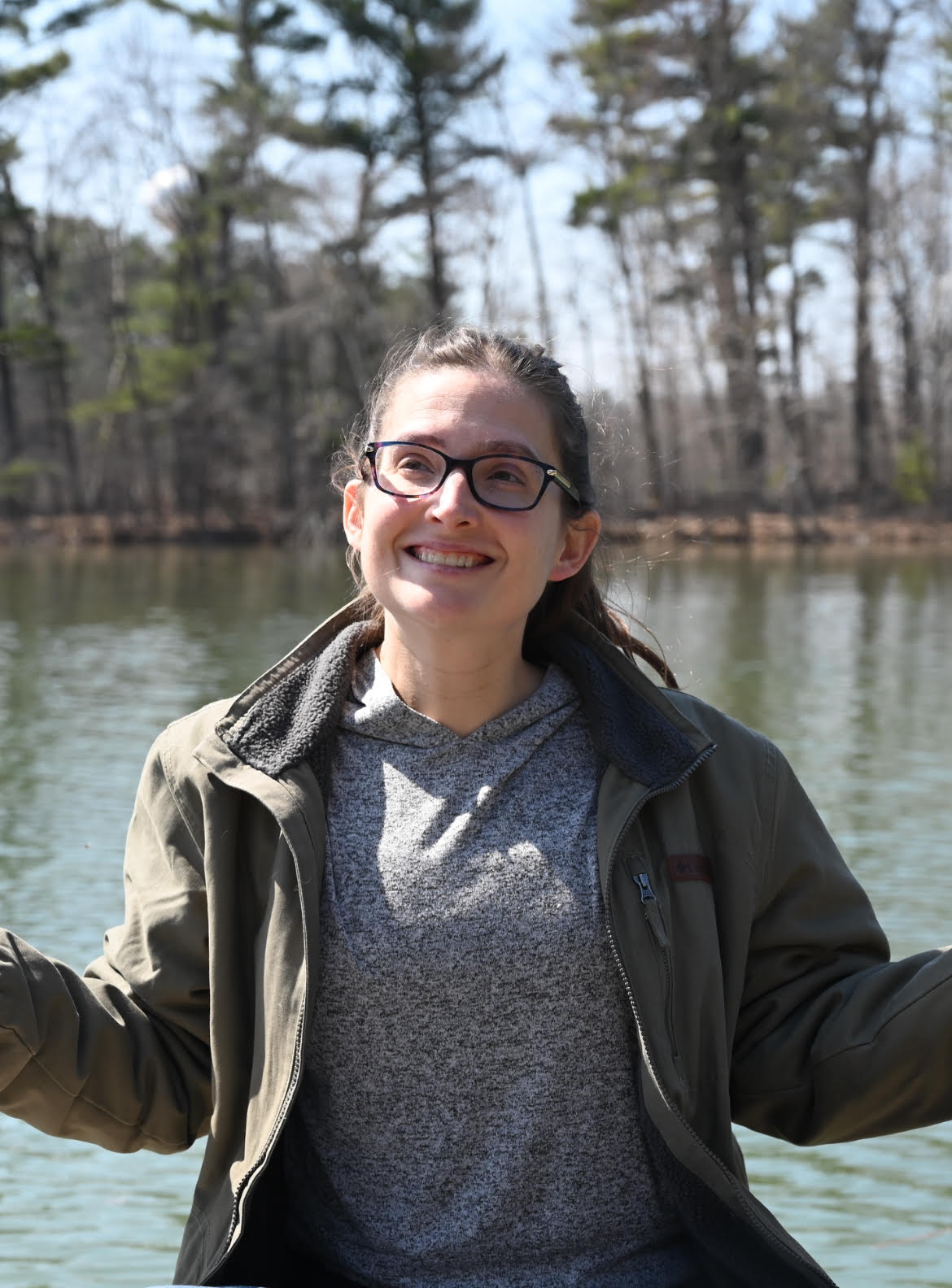 Emily Doud smiling outdoors by a lake